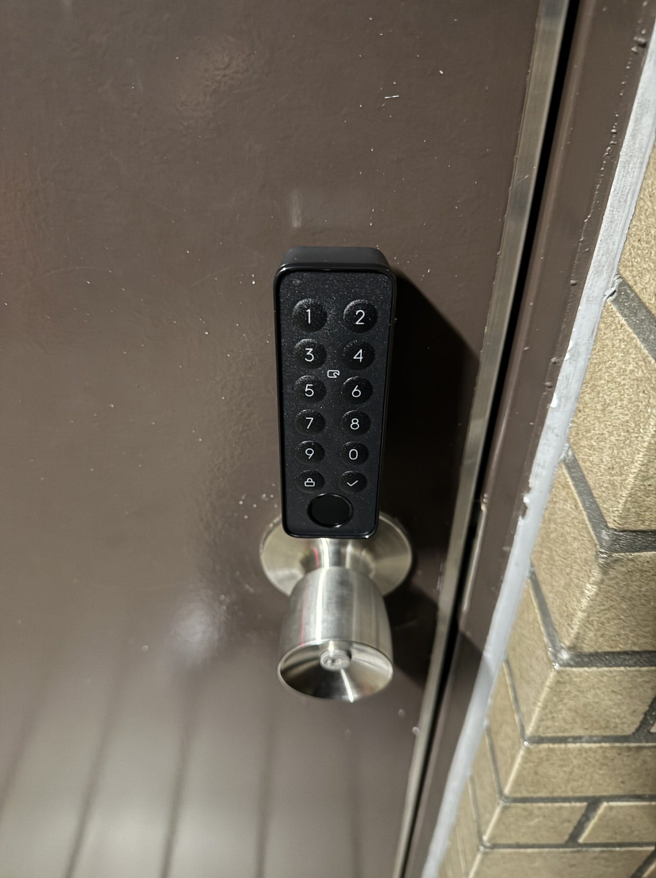 画像 ドア外側に設置した指紋認証パッド。テンキーの数字ボタンと丸ノブが並んでいる